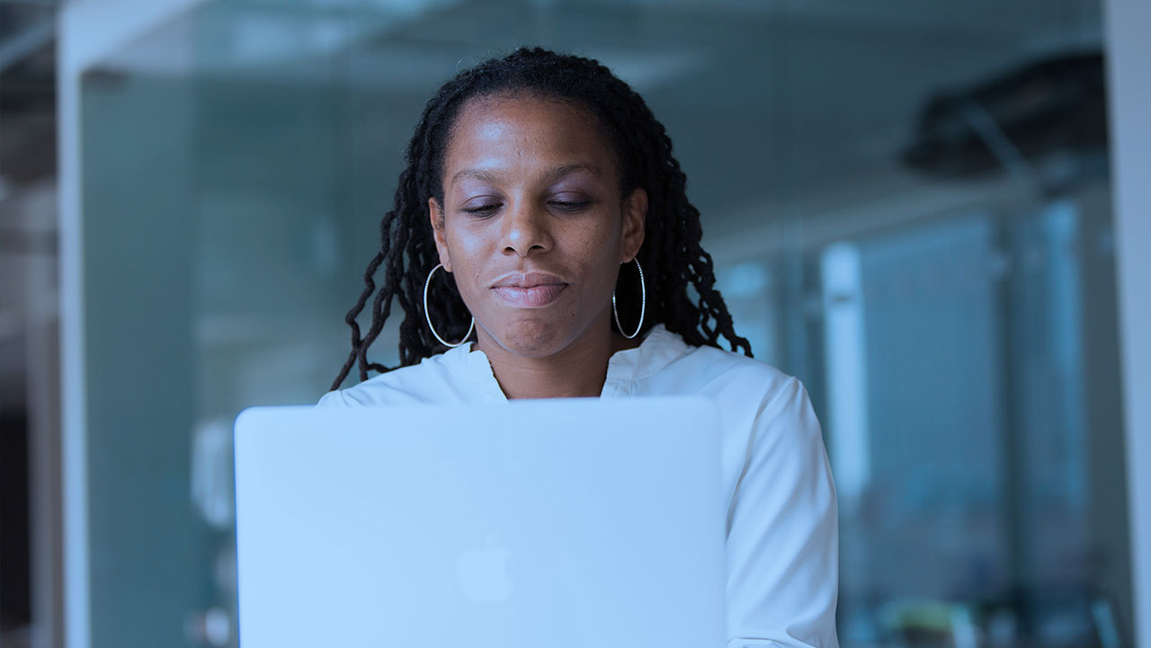 A real estate investor is reviewing her batch skip tracing results on her laptop. 